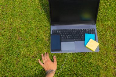 Eli metal bir zincirle dizüstü bilgisayara bağlanmış. Cihazlara, sosyal ağlara ve internete bağımlılık kavramı, bağlılık ve şefkat, uzak çalışma özgürlüğü tuzağı.