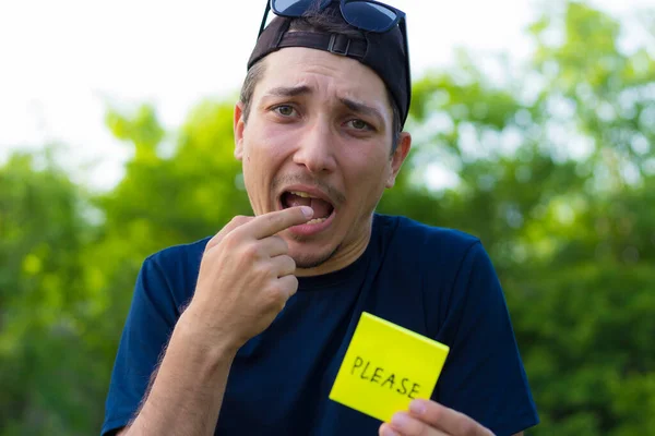 Ung Man Håller Ett Klistermärke Sina Händer Med Texten Please — Stockfoto