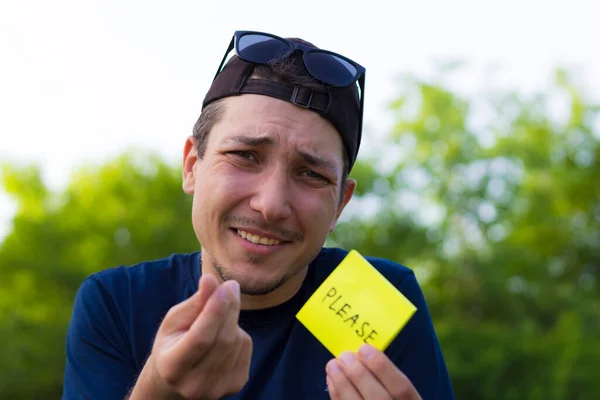 Ein Junger Mann Hält Einen Aufkleber Mit Der Aufschrift Bitte — Stockfoto