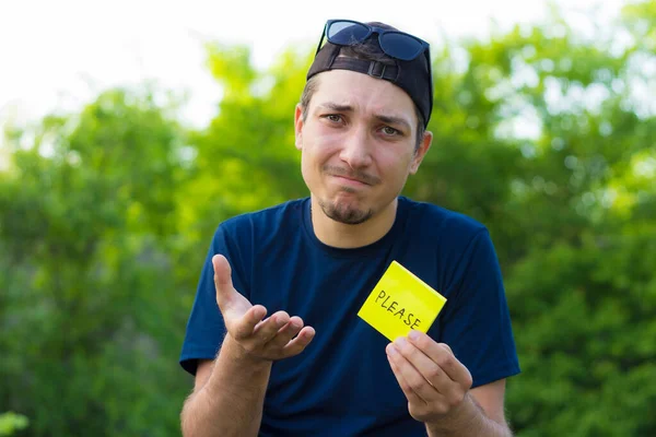 Ung Man Håller Ett Klistermärke Sina Händer Med Texten Please — Stockfoto