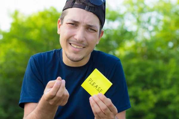 Ung Man Håller Ett Klistermärke Sina Händer Med Texten Please — Stockfoto