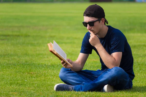 Joven Pasa Tiempo Libre Sentado Césped Con Libro Tonificado Concepto —  Fotos de Stock