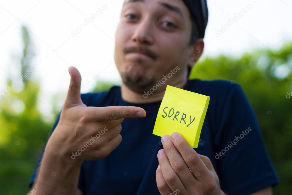 Sorry sticker in male hand, concept of chance