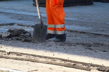 İşçiler yeni asfalt döşemek için eski kaldırımı kaldırıyorlar. Yol onarımı