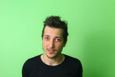 Yakışıklı, mutlu, gülümseyen adam mı yoksa açık yeşil arka plana bakan genç adam mı?