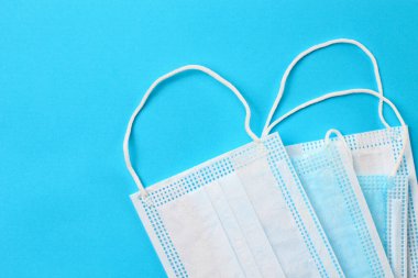 Klasik mavi arka planda tıbbi maske. Covid-19 pandemik ve kamuya açık alanlardaki koruyucu tedbirlerin teması