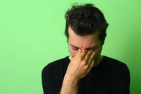 Расстроенный Молодой Человек Светло Зеленом Фоне Стены Эмоции Огорчения Горя — стоковое фото