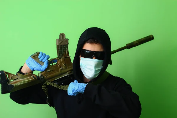 若い男性ギャングや医療外科マスクやフード付きの黒い服に身を包んだサングラスで犯罪者は 自動攻撃兵器を保持しています — ストック写真