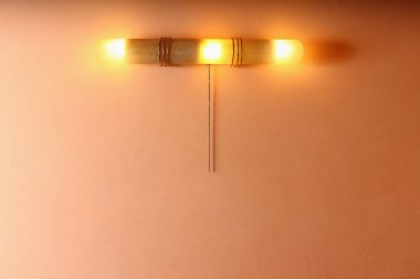 Otel odasında zinciri olan bir duvarda sıcak bir gece lambası. Arkaplan