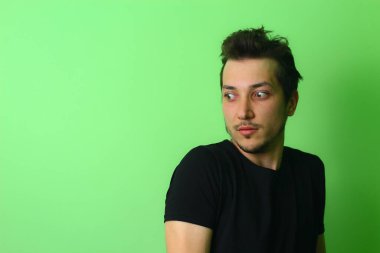 Açık yeşil arka planda etkileyici bir genç adam ya da adam. Korku hissi.