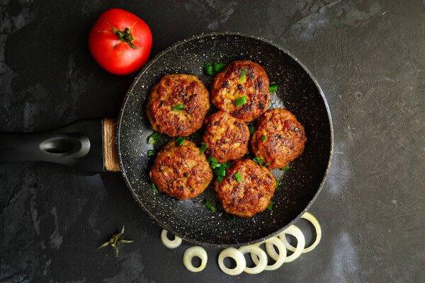 Meatballs in a pan on a black concrete table background. Top view