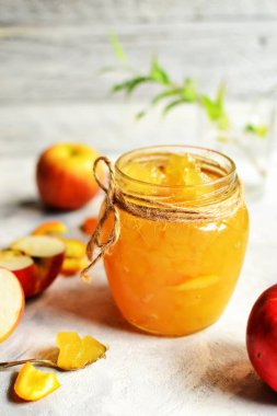 Şeffaf cam kavanozda elma reçeli. Hafif arka planda elma ve portakaldan reçel. Lezzetli marmelat..