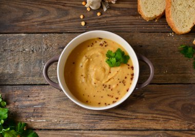 Ahşap arka planda bir kasede bezelye kremalı çorba. Bezelye püresi ve lapa..