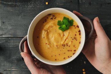 Ahşap arka planda bir kasede bezelye kremalı çorba. Bezelye püresi ve lapa..