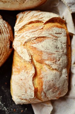 Fırın ürünleri. Koyu arka planda çıtır çıtır, güzel bir ekmek. Karabuğday, mayasız, keten ve ayçiçeği tohumlu buğday ekmeği. Üst görünüm, metin için yer.
