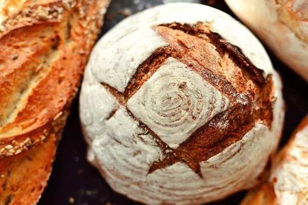 Fırın ürünleri. Koyu arka planda çıtır çıtır, güzel bir ekmek. Karabuğday, mayasız, keten ve ayçiçeği tohumlu buğday ekmeği. Üst görünüm, metin için yer.