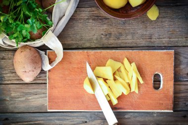 Patates doğrama. Aşama aşama. Kızarmış patates tarifi. Ahşap arka. Kadın yemek yapıyor. Üst Manzara. Metin için yer.