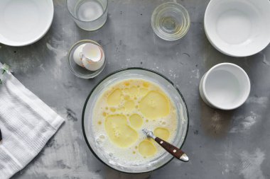 İnce ev yapımı krepler. İnce krep tarifi. Hafif beton arka plan. Üst Manzara. Geleneksel krepleri adım adım pişiriyorum. İçindekiler.