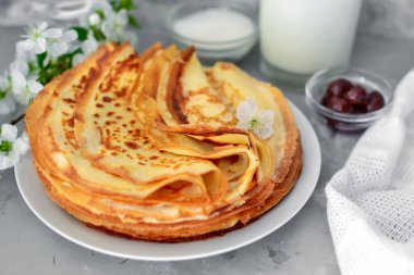 İnce ev yapımı krepler. Hafif arkaplan. Evde ya da kafede güzel ve lezzetli bir kahvaltı. Kiraz ve böğürtlenli ince aromalı krepler. Yan görünüm.