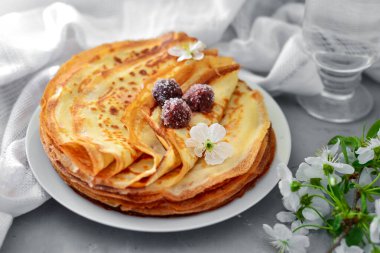 Thin homemade pancakes. Light background. Beautiful and delicious breakfast at home or in the cafe. Thin aromatic pancakes with cherries and berries. Side view. clipart