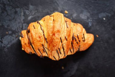 Karanlık bir masada izole edilmiş kruvasanlar. Lezzetli kahvaltı için lezzetli tatlılar..