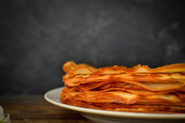 Koyu ahşap arka planda ince krepler. Kapatın. Metin için boş alan.