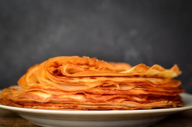 Koyu ahşap arka planda ince krepler. Kapatın. Metin için boş alan.