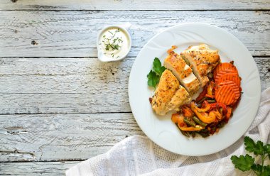 Pişmiş tavuk göğsü ve sebze. Hafif arkaplan. Üst Manzara. Metin Et Yemeği için boş yer. Beyaz tabakta yemek. Lezzetli sağlıklı öğle yemeği.