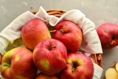 Sepette kırmızı elmalar. Tahta bir arka planda hasır bir sepette olgun elmalar, üst manzara..