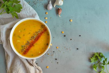 Beyaz kasede bezelye çorbası. Mavi arka planda bir tabakta bezelye kremalı çorba. Sağlıklı, lezzetli vejetaryen yemekleri..