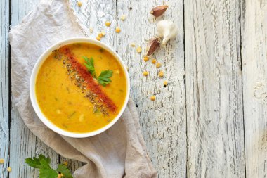 Beyaz kasede bezelye çorbası. Hafif ahşap zemin üzerinde bir tabakta bezelye kremalı çorba. Sağlıklı vejetaryen yemeği. Metin için boş alan.