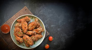 Susamlı fırında tavuk kanadı. Ketçap ve acı sos. Metin için boş alan. Üst Manzara. Lezzetli kızarmış tavuk kanatları..