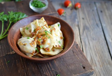 Patates dolgulu börek. Kil tabakta hamur köftesi. Metin için boş alan. Koyu tahta arkaplan.
