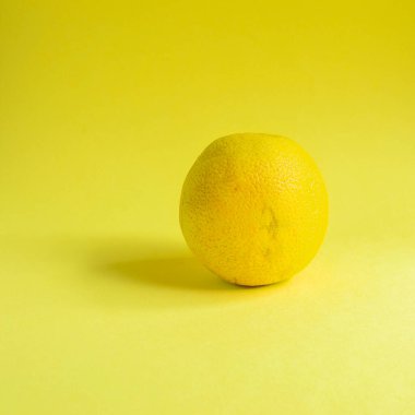 Minimum gıda konsepti. Parlak sarı arka planda limon. Metin için boş alan. Üst Manzara. Minimalizm. Yaratıcı narenciye.