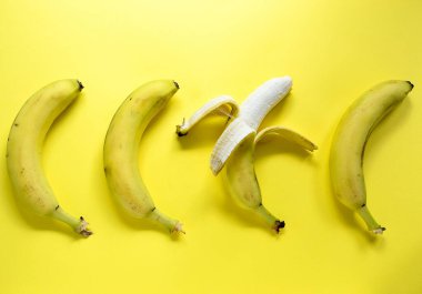 Parlak sarı arka planda muzlar. Minimalizm.