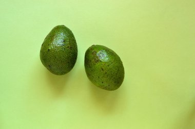 Avokadoyu kes. Pastel pembe arka planda avokado. Metin için boş alan. Üst Manzara. Düz yatıyordu. Minimalizm