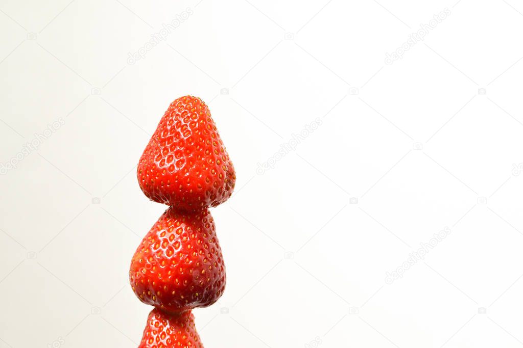 Minimal food concept. Strawberries on a white background. Three sexy strawberries isolated on white. Free space for text. Minimalism