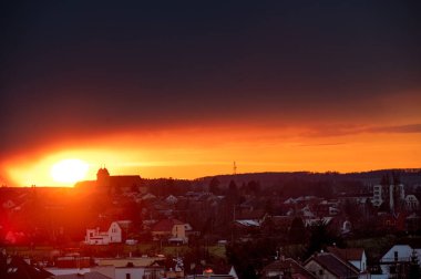 Şehrin üzerinde güzel bir gün doğumu alacakaranlığı. Horizont, bulutlu gökyüzü.