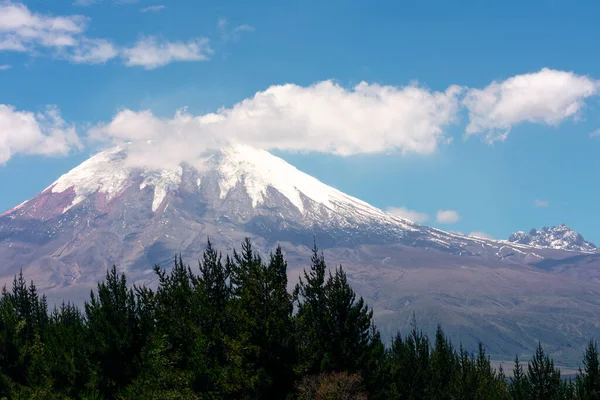 Ekvador 'daki Cotopaxi volkanı, bir bahar günü dağların arkasında az miktarda bulutla mavi gökyüzü