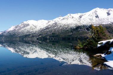 Karlı dağ, Arjantin 'in Bariloche şehrinde kış boyunca Guillelmo Gölü' ne yansıdı.