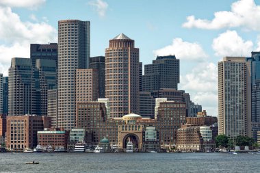 Güney Boston Liman Bölgesi güzel bir yaz gününde Boston Limanı 'ndan görüldüğü gibi. Sahil şeridi boyunca ofis binaları, oteller ve müzeler görülebilir. Çeşitli boyutlarda birkaç tekne ve ön planda küçük bir kayık görünmektedir.. 