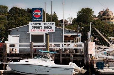 North Shore Sport Rıhtımı, Gloucester Limanı 'nda bulunan klasik bir kurumdur. Bakış, basit zamanların geçtiği bir günü işaret ediyor. Gri ahşap bir katlı bina, kalabalık bir rıhtımda tekne tutkunları ve balıkçılara yakıt, yiyecek ve içecek servisi yapıyor.. 