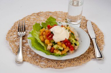 Beyaz tabakta tavuklu Sezar salatası