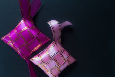 Ketupat. Koyu arkaplanı olan güzel renkli ketupat şeritleri.