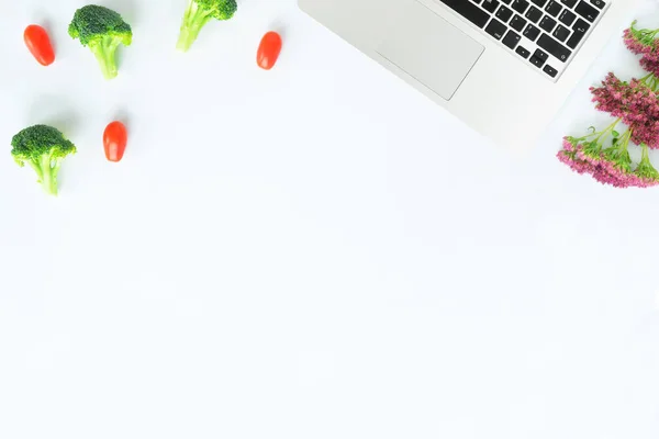 Робоче місце з броколі, помідорами з ноутбуком — стокове фото