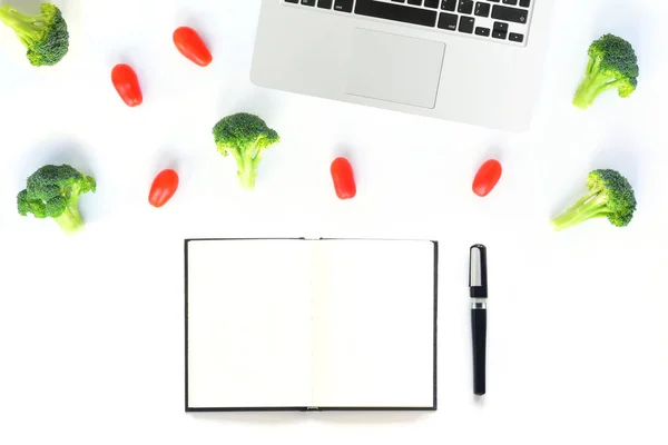 Робоче місце з броколі, помідорами та блокнотом з ноутбуком — стокове фото