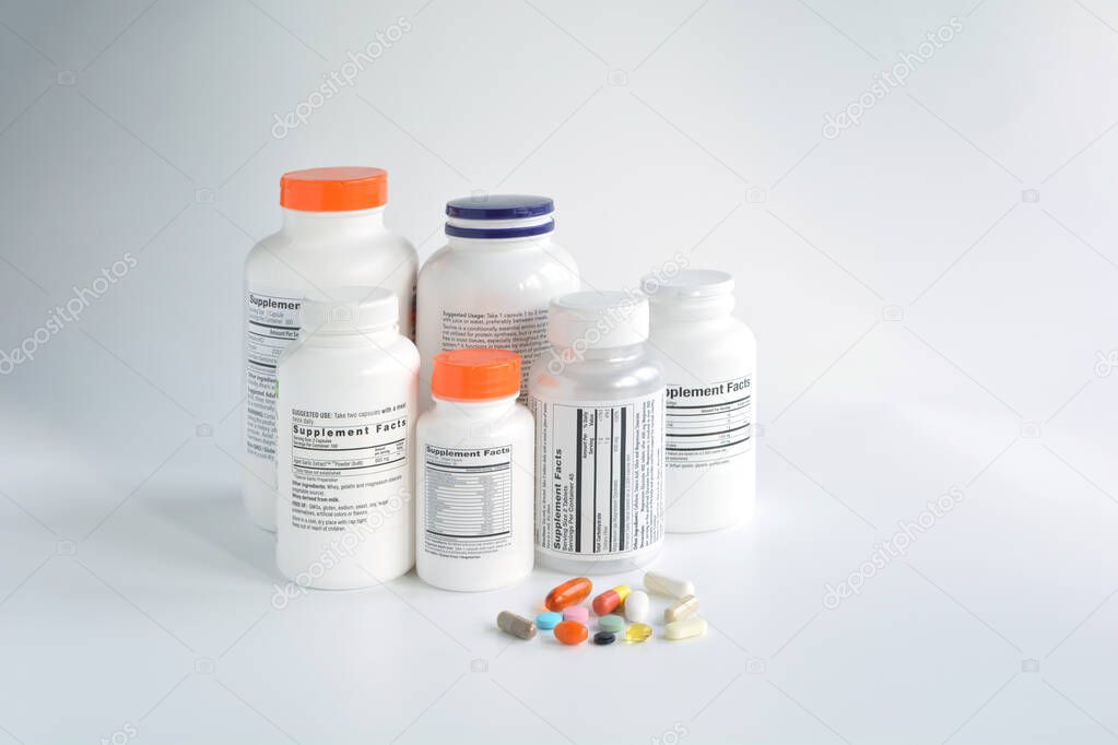 Group of supplement bottle with pills on a white background
