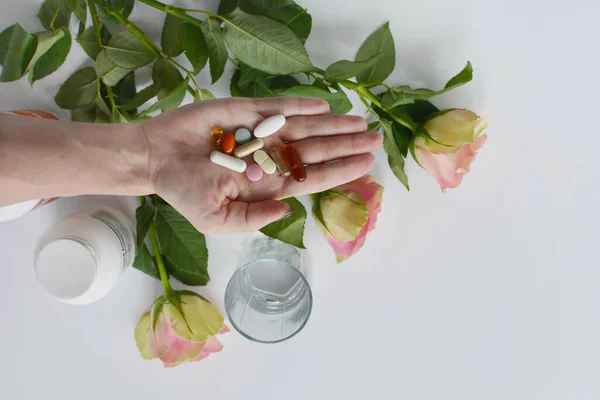 Supplemento per la bellezza e la mano con pillole su sfondo bianco — Foto Stock