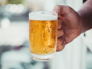 Soğuk bira kavanozunu tutan el.