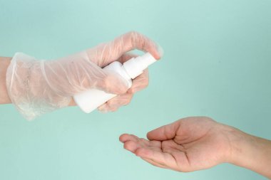 Tıbbi eldiven içinde beyaz bir şişe antibakteriyel antiseptikle el tedavisi için antibakteriyel antiseptik bulundurur. Salgın, virüsler, sararlar, koronavirüs, sağlık konsepti...